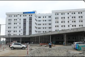 front of the large hospital at Kannigapuram showing the building painted white but roads not yet finished may 2020