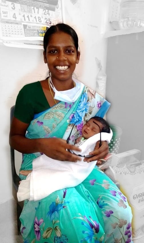Madhu sitting in outpatients with her young baby after her surgery during the CoVid pandemic in 2020