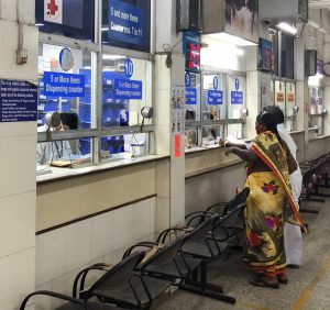 a row of counters in pharmacy with patients getting their medicines