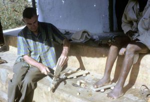 Paul brand carves the a wooden shoe for a patient who has deformed feet