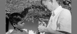 Paul brand examins the hands of a boy. they have been paralysed and deformed due to Hansen's Disease.